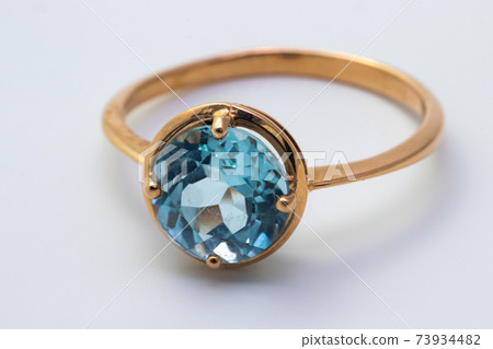 Beautiful old golden ring with blue gemstone isolated on white background 73934482