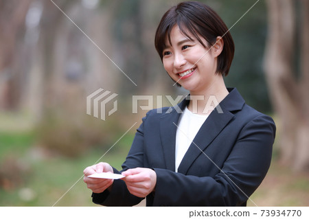 Female employees exchanging business cards 73934770