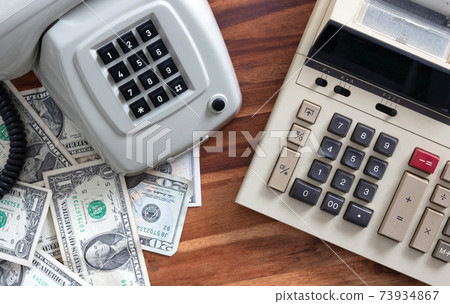 Old fashioned calculator, telephone and dollars Old fashioned calculator, telephone and dollars 73934867