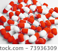 A large number of red capsules (medicines, supplements) stock photos 73936309
