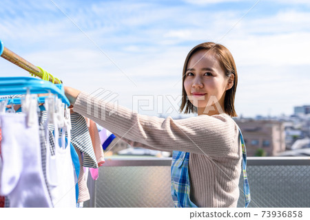 Housewife drying laundry 73936858