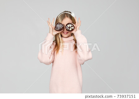 child girl holding in hands two cakes 73937151