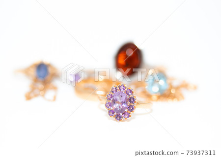 Collection of jewelry with beautiful golden ring with purple stone isolated on white background Collection of jewelry with beautiful golden ring with purple stone isolated on white background 73937311