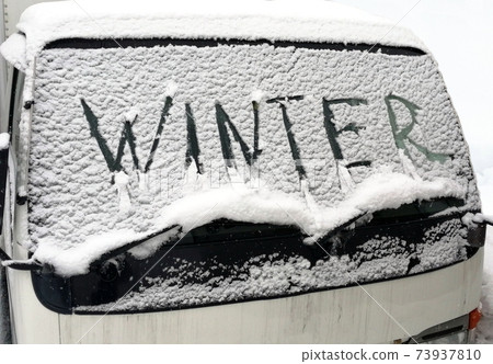 Winter, a car covered with snow. The inscription on the windshield 73937810