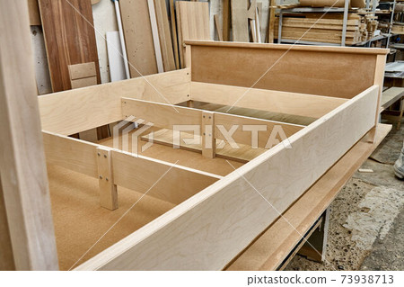 Joinery. Bed building process. Wooden furniture manufacturing process. Furniture manufacture. Close-up Joinery. Bed building process. Wooden furniture manufacturing process. Furniture manufacture. Close-up 73938713