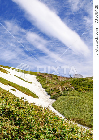 Spring Tairapyoyama mountain trail, snowy valley and clear sky 73939429