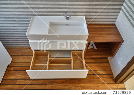 Wall mounted bathroom vanity in luxury bathroom with teak floor. Stylish interior of modern bathroom. Details furniture Wall mounted bathroom vanity in luxury bathroom with teak floor. Stylish interior of modern bathroom. Details furniture 73939859