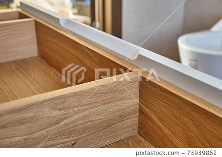Opened wooden drawer of bathroom vanity in luxury bathroom with teak floor. Stylish interior of modern bathroom. Details furniture 73939861
