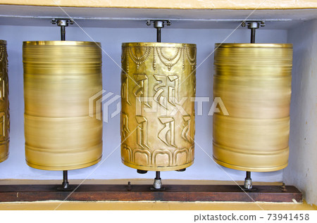 tibetan Buddhist prayer wheels in McLeod Ganj temple, India tibetan Buddhist prayer wheels in McLeod Ganj temple, India 73941458