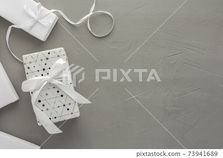 Gift boxes with a bow on a gray concrete background 73941689