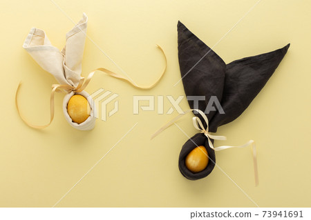 Easter bunnies from napkin and golden painted egg 73941691