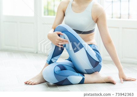 A woman stretching in her room 73942363