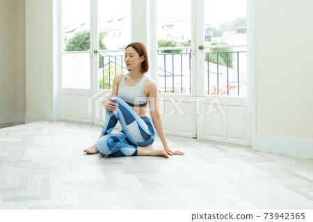 A woman stretching in her room 73942365