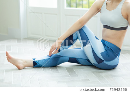 A woman stretching in her room A woman stretching in her room 73942366