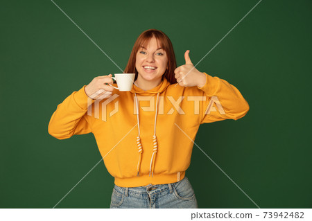 Caucasian woman's portrait isolated on green studio background with copyspace Caucasian woman's portrait isolated on green studio background with copyspace 73942482