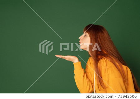 Caucasian woman's portrait isolated on green studio background with copyspace 73942500