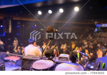 A microphone on stage concert with colorful lighting laser beam spotlight show in disco pub club bar background for party music dancing festival performance. Entertainment nightlife. Celebration event 73943605