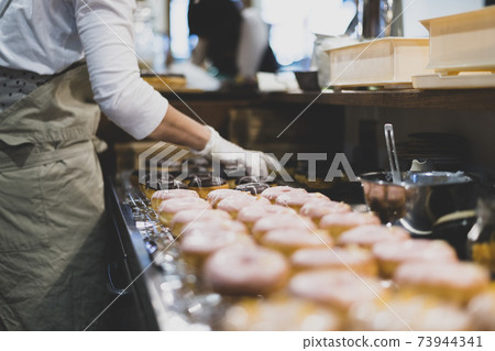 Woman making donuts 73944341