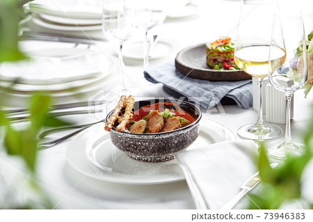 Caesar salad with bread sticks, quail eggs, cherry tomatoes and grilled chicken in plate on white background 73946383