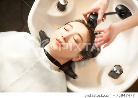 Young woman having her hair washed at a beauty salon Young woman having her hair washed at a beauty salon 73947477