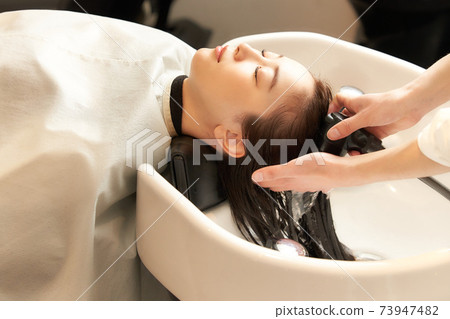 Young woman having her hair washed at a beauty salon Young woman having her hair washed at a beauty salon 73947482
