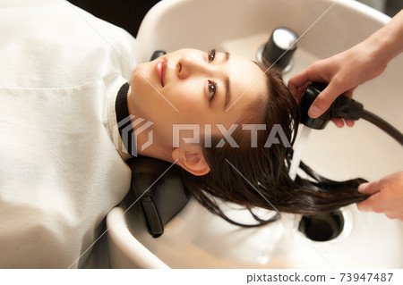 Young woman having her hair washed at a beauty salon Young woman having her hair washed at a beauty salon 73947487