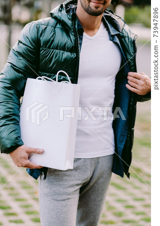 man holding White paper bag and white t-shirt mockup 73947896