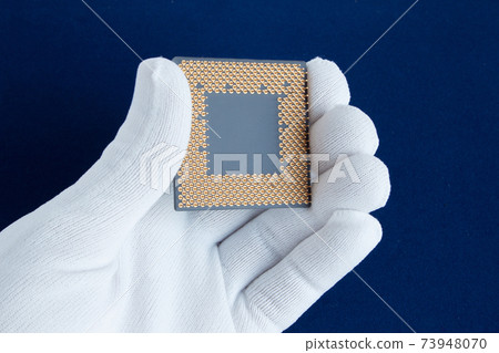 Hand in white glove holds the CPU. Closeup. Hand in white glove holds the CPU. Closeup. 73948070