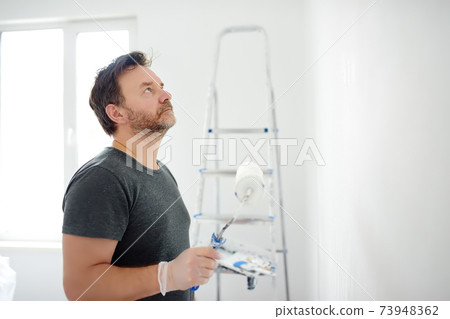 Portrait of a handsome mature man making repairs in the apartment. DIY Portrait of a handsome mature man making repairs in the apartment. DIY 73948362