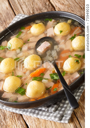 Hafalaab Traditional Liechtenstein soup with ham and cornmeal dumplings closeup in the plate on the table. vertical 73949010