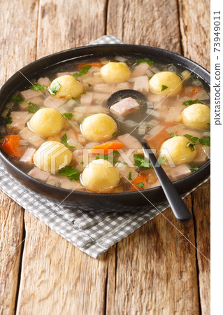 Liechtenstein Ham Soup And Cornmeal Dumplings closeup in the plate. vertical Liechtenstein Ham Soup And Cornmeal Dumplings closeup in the plate. vertical 73949011
