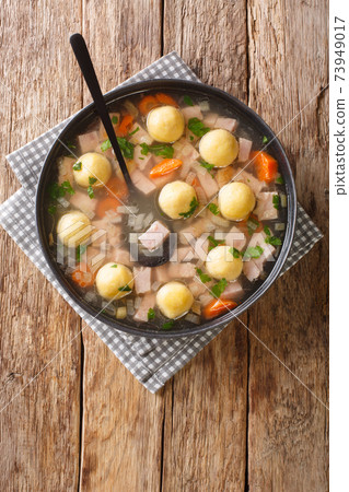 Liechtenstein Ham Soup And Cornmeal Dumplings closeup in the plate. vertical top view Liechtenstein Ham Soup And Cornmeal Dumplings closeup in the plate. vertical top view 73949017