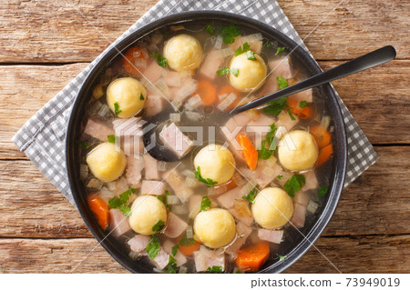 Delicious Liechtenstein cuisine soup with ham and cornmeal dumplings close-up in a plate. horizontal top view Delicious Liechtenstein cuisine soup with ham and cornmeal dumplings close-up in a plate. horizontal top view 73949019