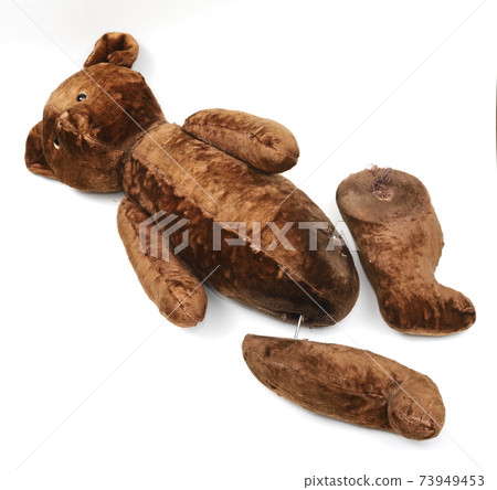 broken toy teddy bear with severed paws on a white 73949453