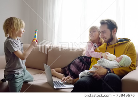 Tired freelancer father with his three kids during quarantine. Home office and household  73949676