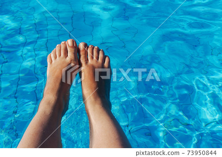 naked female legs on a background of blue water 73950844