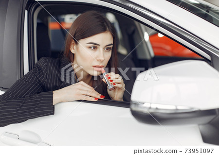 Stylish and elegant woman in a car salon Stylish and elegant woman in a car salon 73951097
