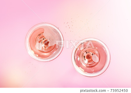Two glasses with sparkling rose wine on pink background Two glasses with sparkling rose wine on pink background 73952450