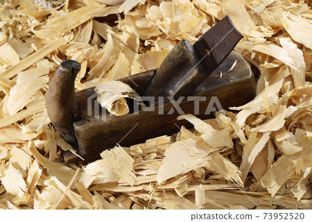 a lot of fresh wood shavings and vintage planer 73952520