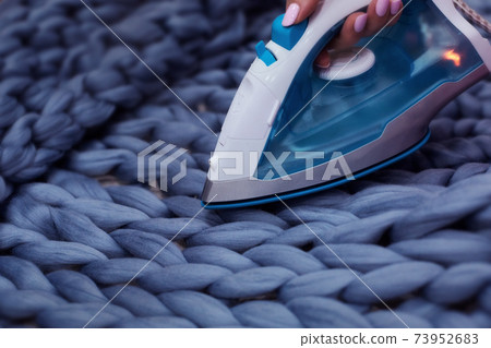 Ironing. Hand made knit blanket process Ironing. Hand made knit blanket process 73952683