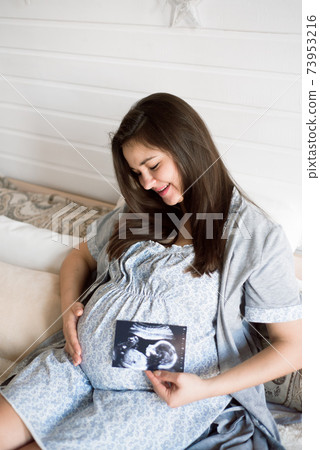 Pregnant woman holding ultrasound scan. Pregnancy health concept. 73953216