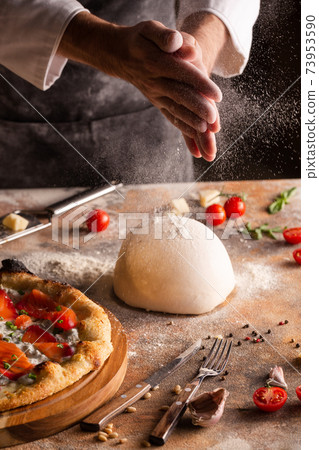 Chef preparing pizza dough at home or in the kitchen. 73953590