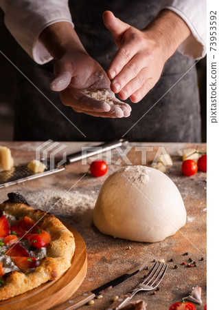 Chef preparing pizza dough at home or in the kitchen. 73953592