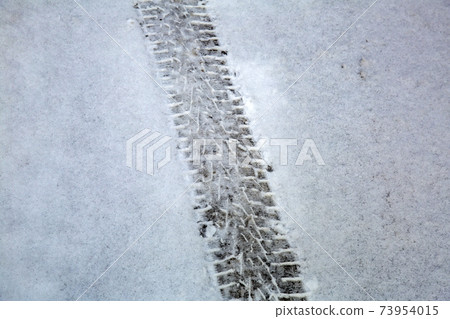 Traces of car wheels on white snow Traces of car wheels on white snow 73954015