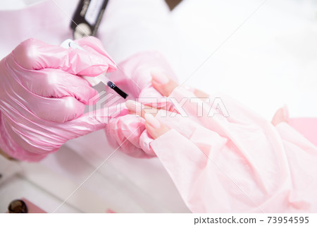 Hands in gloves cares about hand nails. Manicure beauty salon. Hands in gloves cares about hand nails. Manicure beauty salon. 73954595