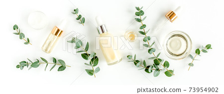 Eucalyptus essential oil, eucalyptus leaves on white background. Natural, Organic cosmetics products. Medicinal, Natural Serums. Flat lay, top view. 73954902