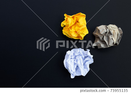 Crumpled paper balls on dark background. 73955135