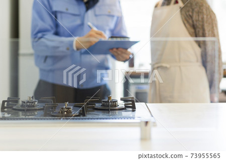 一個穿著工作服的人檢查燃氣灶 一個穿著工作服的人檢查燃氣灶 73955565