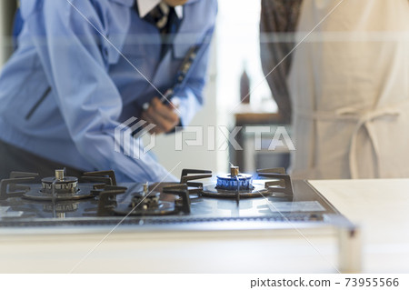 A man in work clothes checking a gas stove 73955566