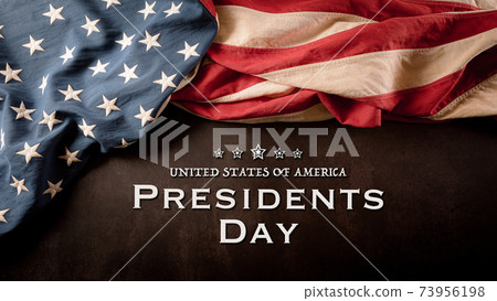 Happy presidents day concept with vintage flag of the United States on dark stone background. 73956198